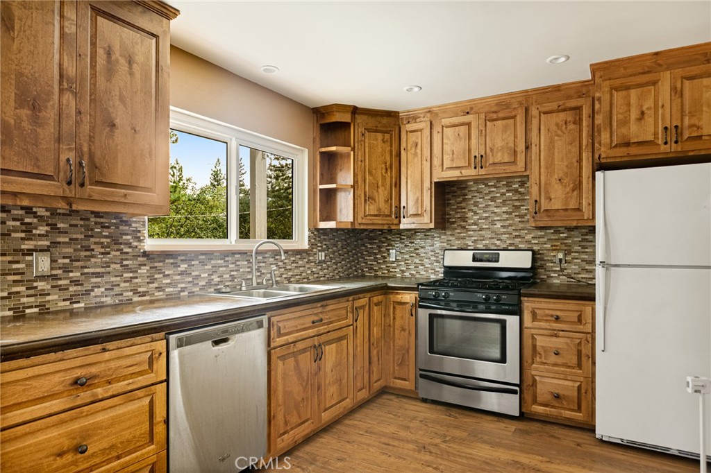 33159 Ridge Drive Running Springs, CA 92382 - Photo 7 of 24 a kitchen with stainless steel appliances granite countertop a stove a sink and a refrigerator