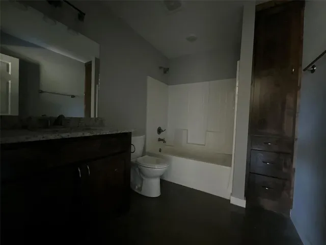 a bathroom with a granite countertop sink a toilet and shower
