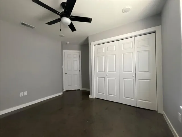 an empty room with a ceiling fan and a window
