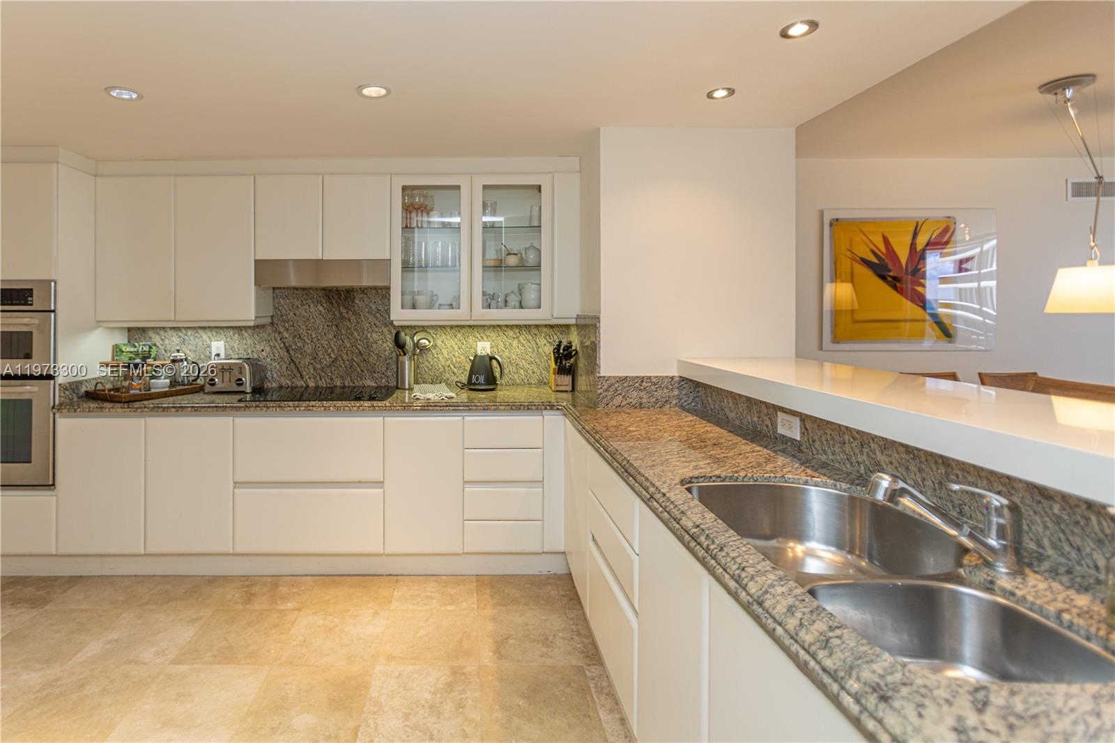 9559 Collins Avenue, Unit S7D Surfside, FL 33154 - Photo 23 of 59 a kitchen with granite countertop a sink and a stove top oven