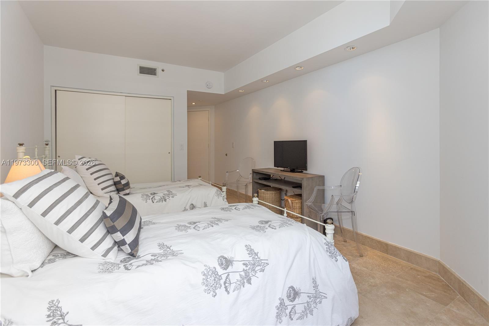 9559 Collins Avenue, Unit S7D Surfside, FL 33154 - Photo 38 of 59 a bedroom with a bed and a tv on the dresser