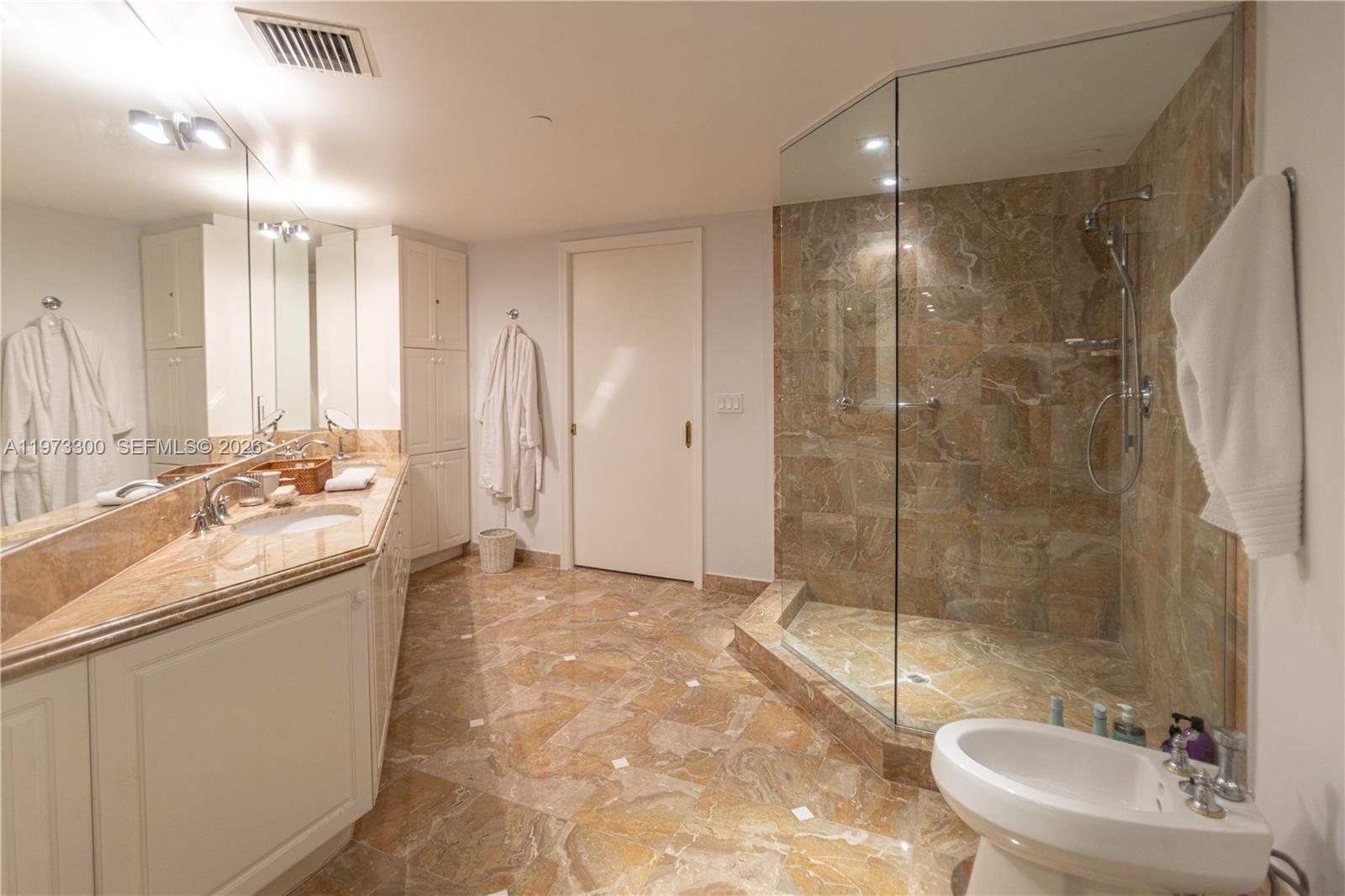 9559 Collins Avenue, Unit S7D Surfside, FL 33154 - Photo 42 of 59 a bathroom with a granite countertop sink a toilet and shower