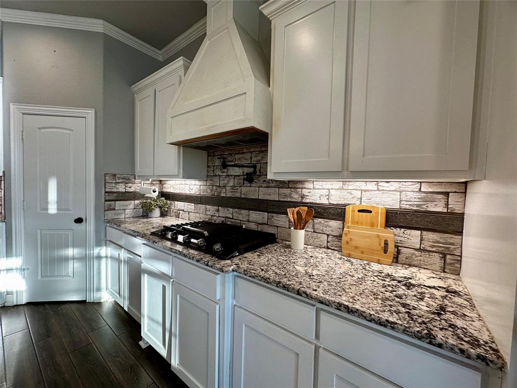 107 Rock Salt Court Springtown, TX 76082 - Photo 6 of 22 a kitchen with granite countertop a sink a stove and cabinets