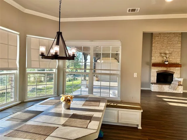 a view of an empty room with wooden floor and a fireplace