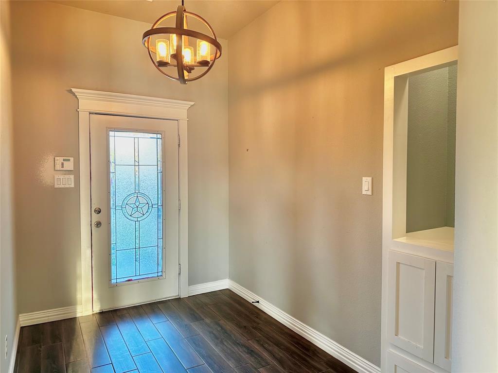107 Rock Salt Court Springtown, TX 76082 - Photo 9 of 22 a view of a hallway with wooden floor and a chandelier