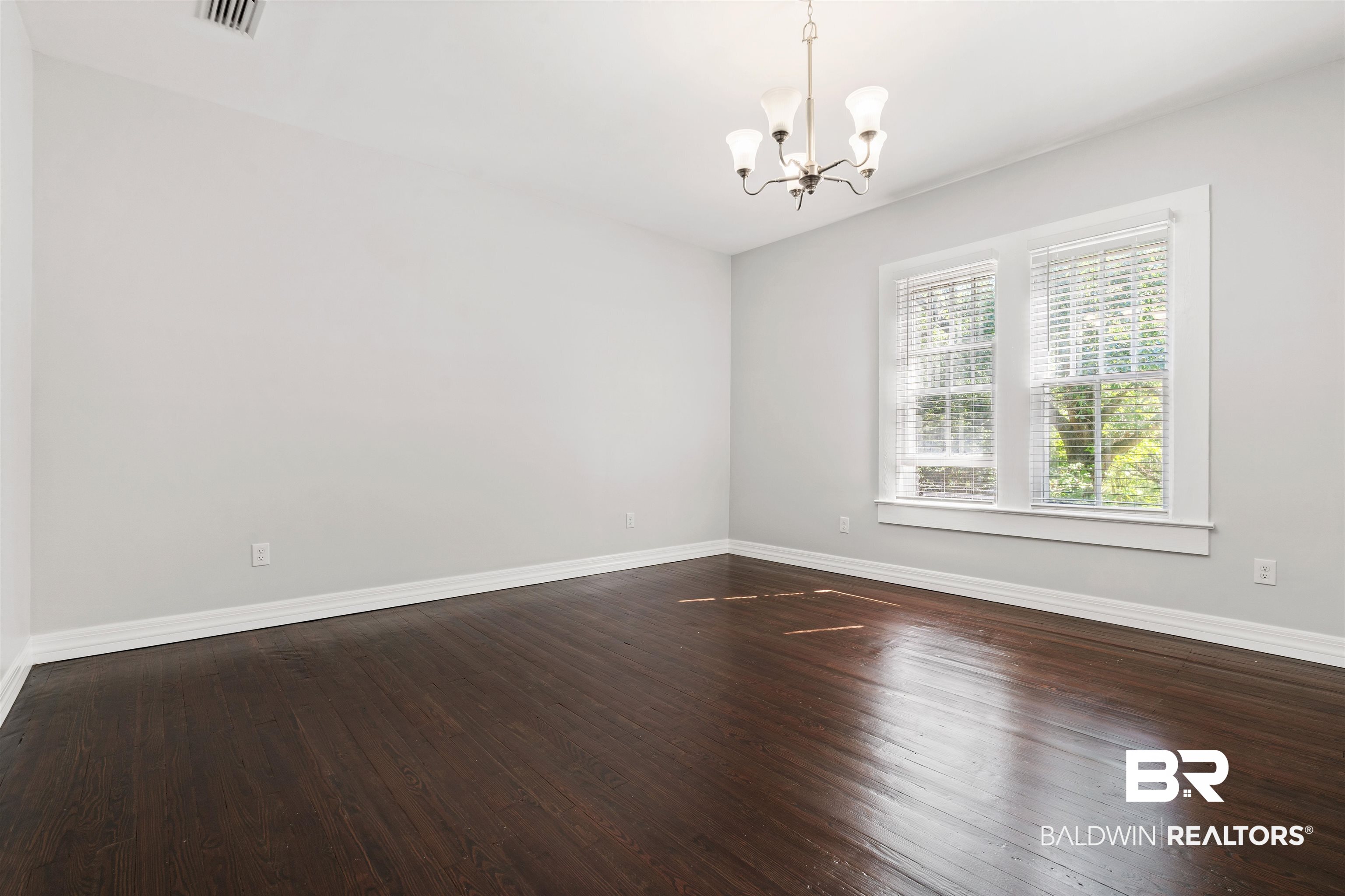 407 East 2nd Street Bay Minette, AL 36507 - Photo 18 of 40 Unfurnished room with dark wood finished floors and a chandelier