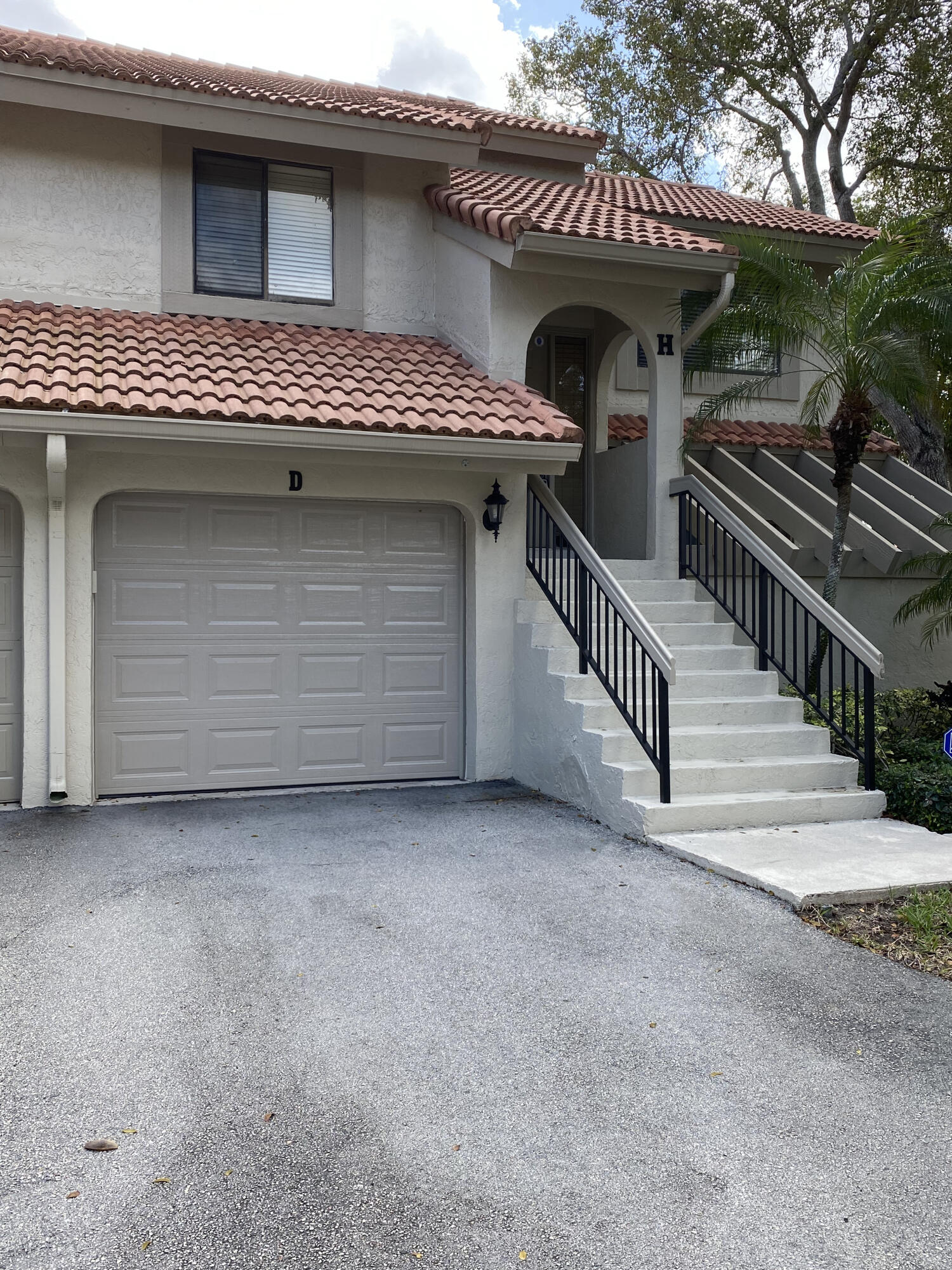 5621 Coach House Circle, Unit D Boca Raton, FL 33486 - Photo 2 of 29 a view of a house with wooden stairs and a table and chairs