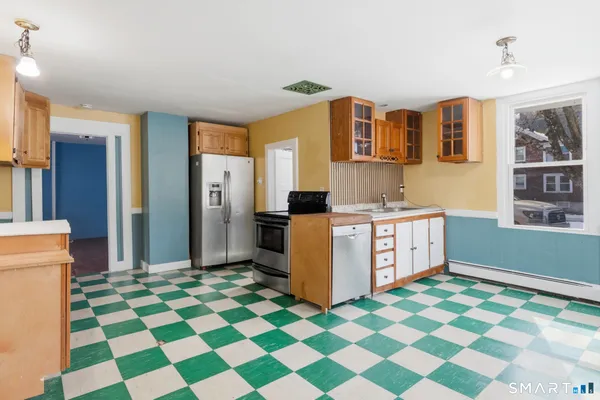 a kitchen with stainless steel appliances granite countertop a sink and a refrigerator
