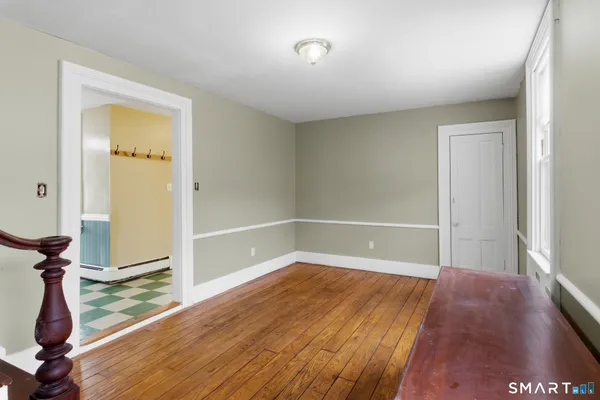 a view of empty room with wooden floor