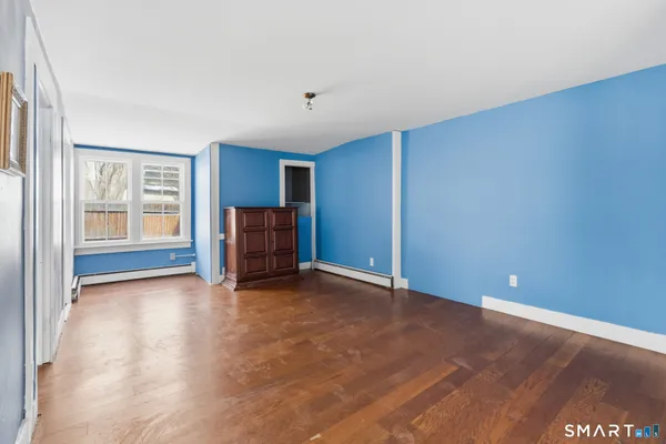 a view of empty room with wooden floor and entryway