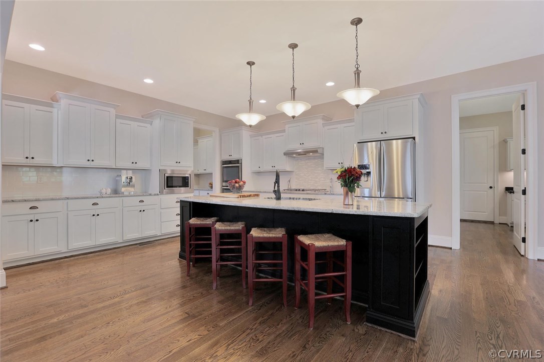 16106 Alsdell Road Midlothian, VA 23112 - Photo 6 of 46 a large kitchen with kitchen island a dining table chairs and a wooden floor