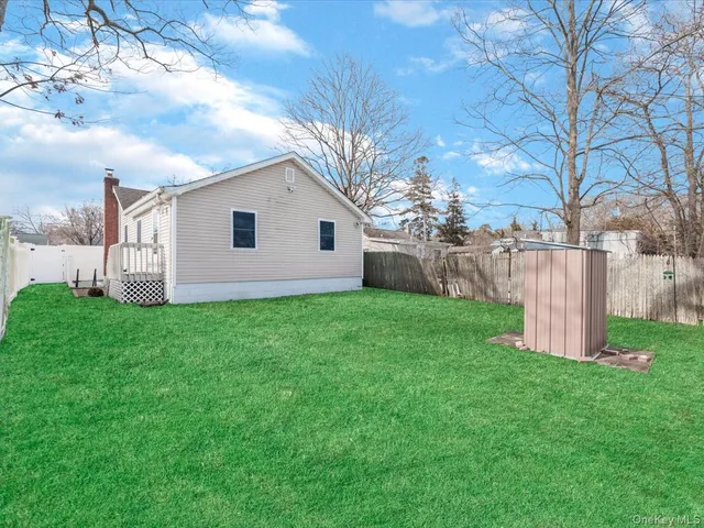 a white house that has a big yard with wooden fence