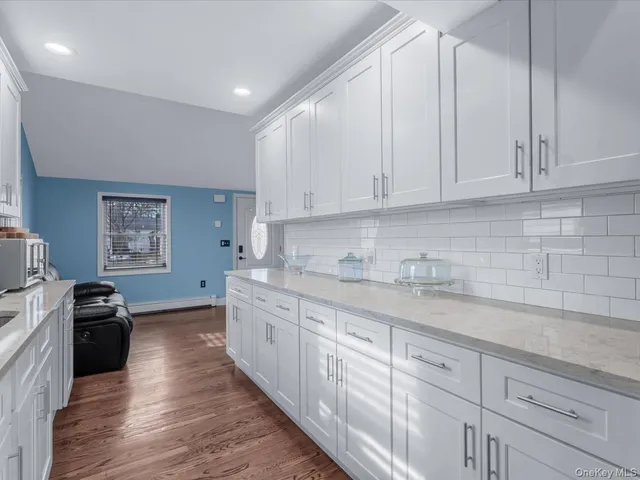 a kitchen with granite countertop white cabinets and stainless steel appliances