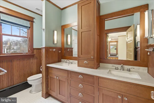 a bathroom with a double vanity sink toilet mirror and bathtub