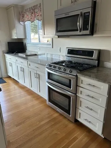a kitchen with stainless steel appliances a stove microwave and sink