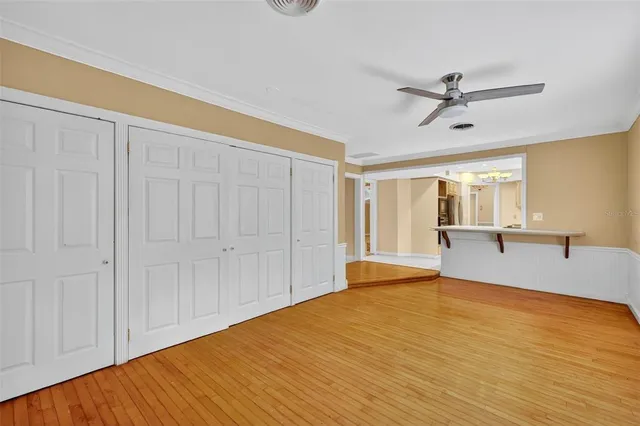 a big room with wooden floor closet and windows