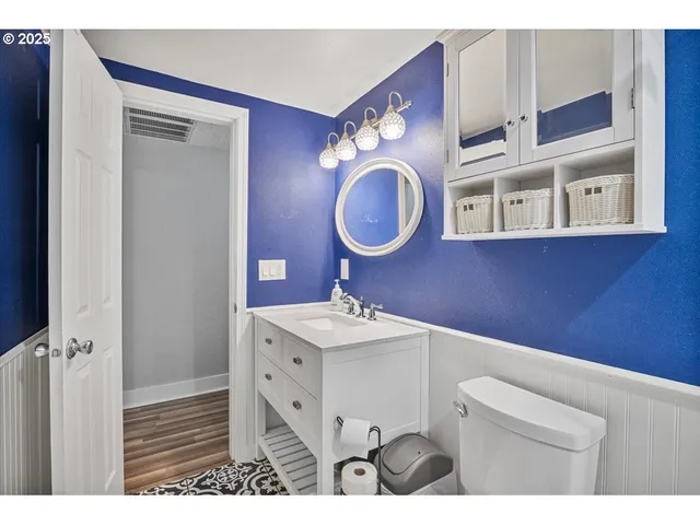 a bathroom with a sink vanity mirror and toilet
