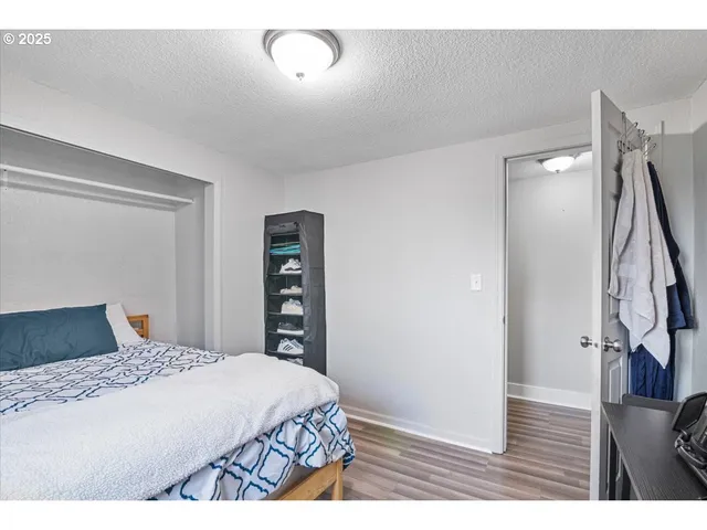 a bedroom with a large bed and a flat tv screen on dresser