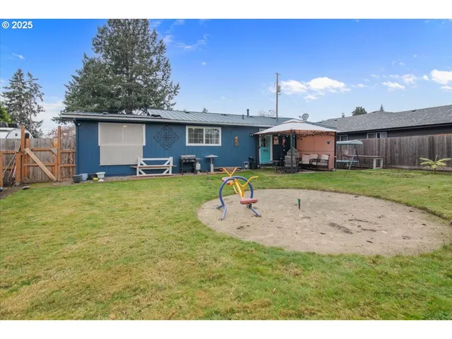 a backyard of a house with table and chairs