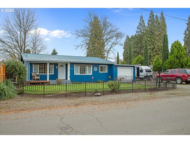 a view of brick house with large windows and a yard