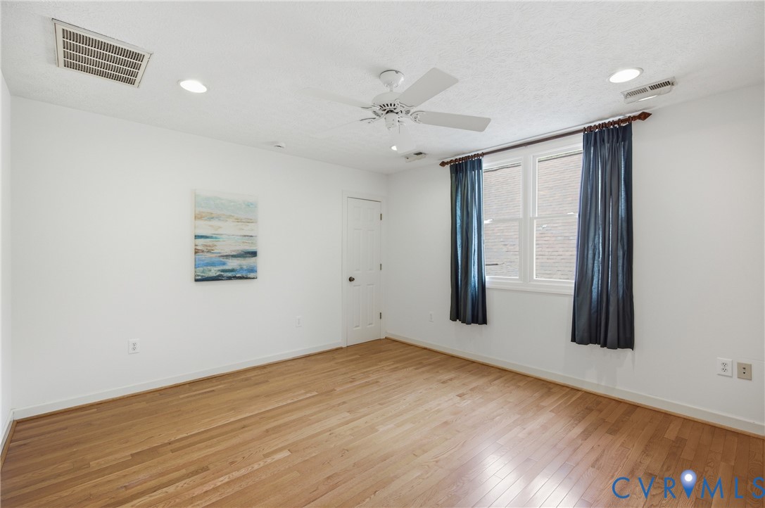 13265 Coulbourn Road Saluda, VA 23149 - Photo 34 of 62 an empty room with wooden floor fan and windows