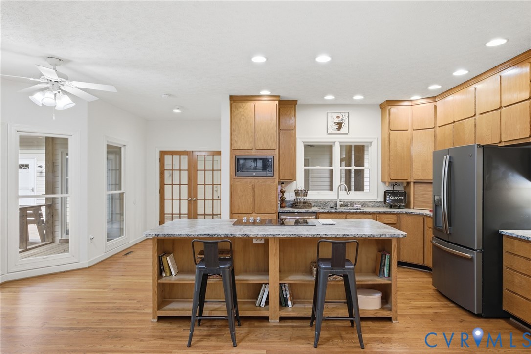 13265 Coulbourn Road Saluda, VA 23149 - Photo 7 of 62 a kitchen with stainless steel appliances granite countertop a stove refrigerator dining table and chairs