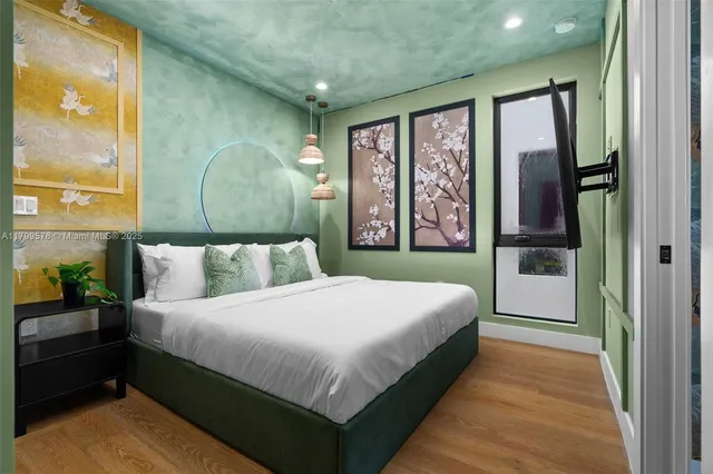 a bedroom with a large window and a flat screen tv