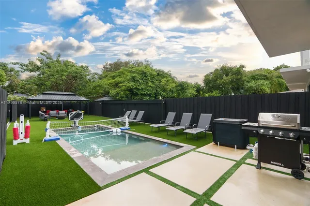 a view of a swimming pool with a patio and a yard