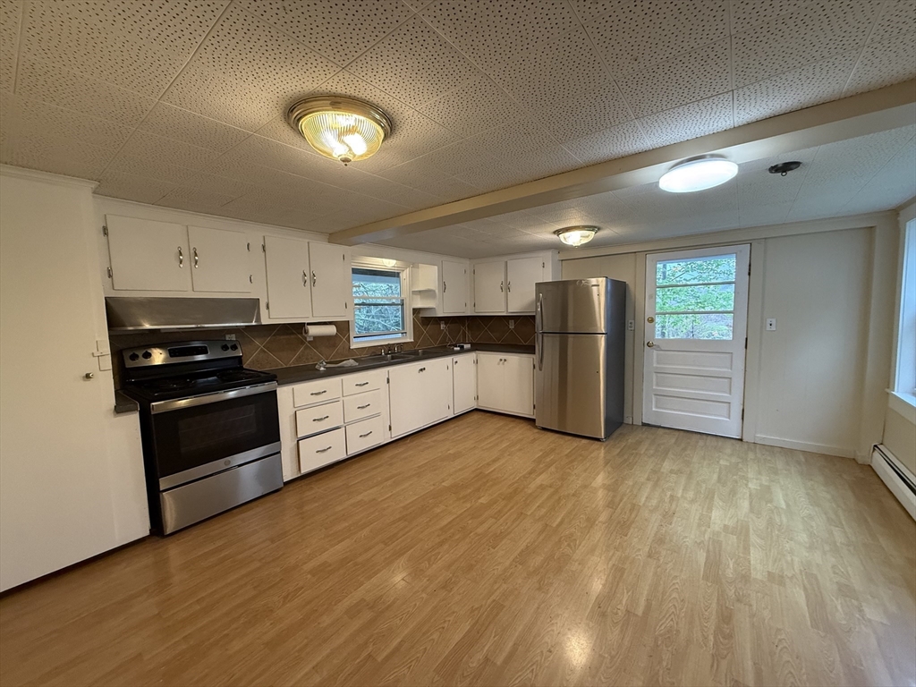 84 Emerald Road, Unit 1 Rutland, MA 01543 - Photo 3 of 22 a kitchen with granite countertop a refrigerator and a stove top oven