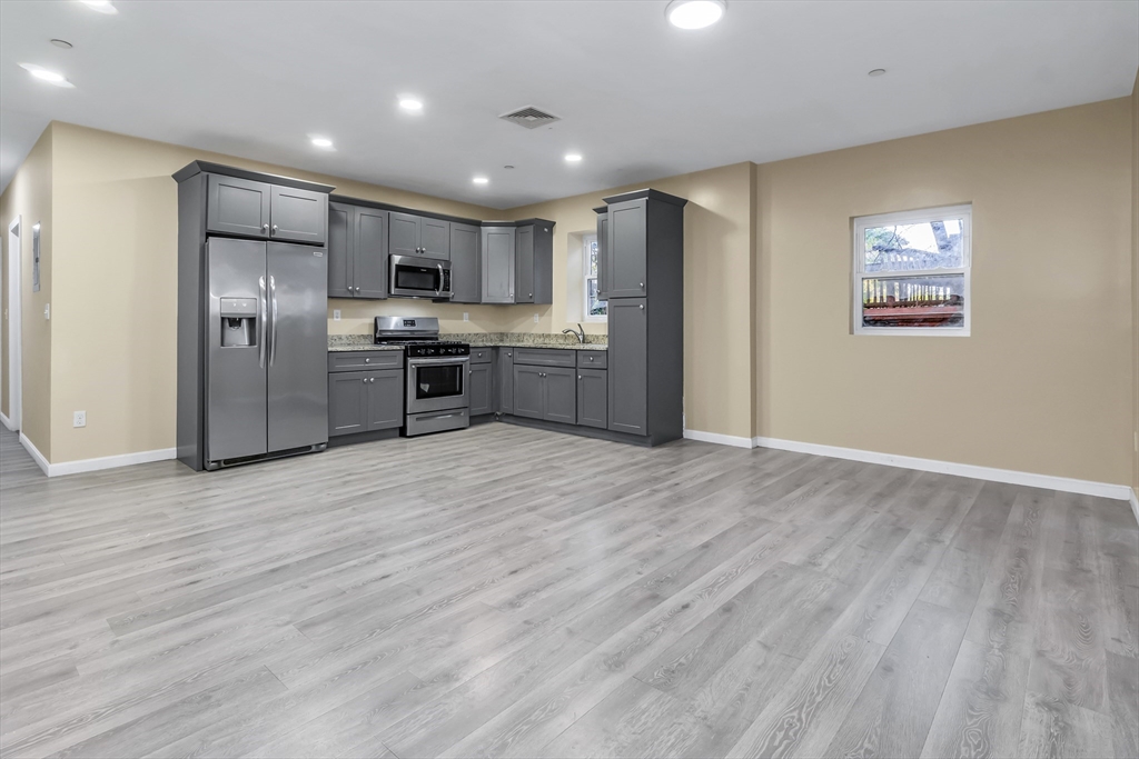 202 Broadway, Unit 23 Lawrence, MA 01840 - Photo 1 of 15 a kitchen with stainless steel appliances granite countertop a refrigerator a sink dishwasher a stove and a refrigerator with wooden floor