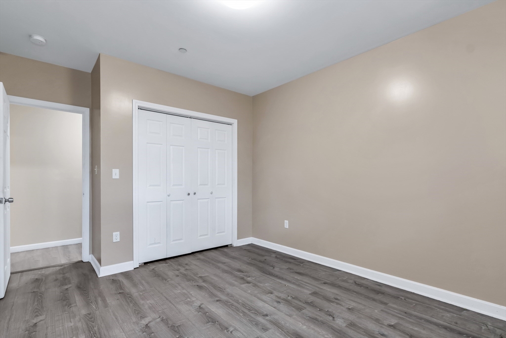 202 Broadway, Unit 23 Lawrence, MA 01840 - Photo 12 of 15 a view of an empty room with wooden floor