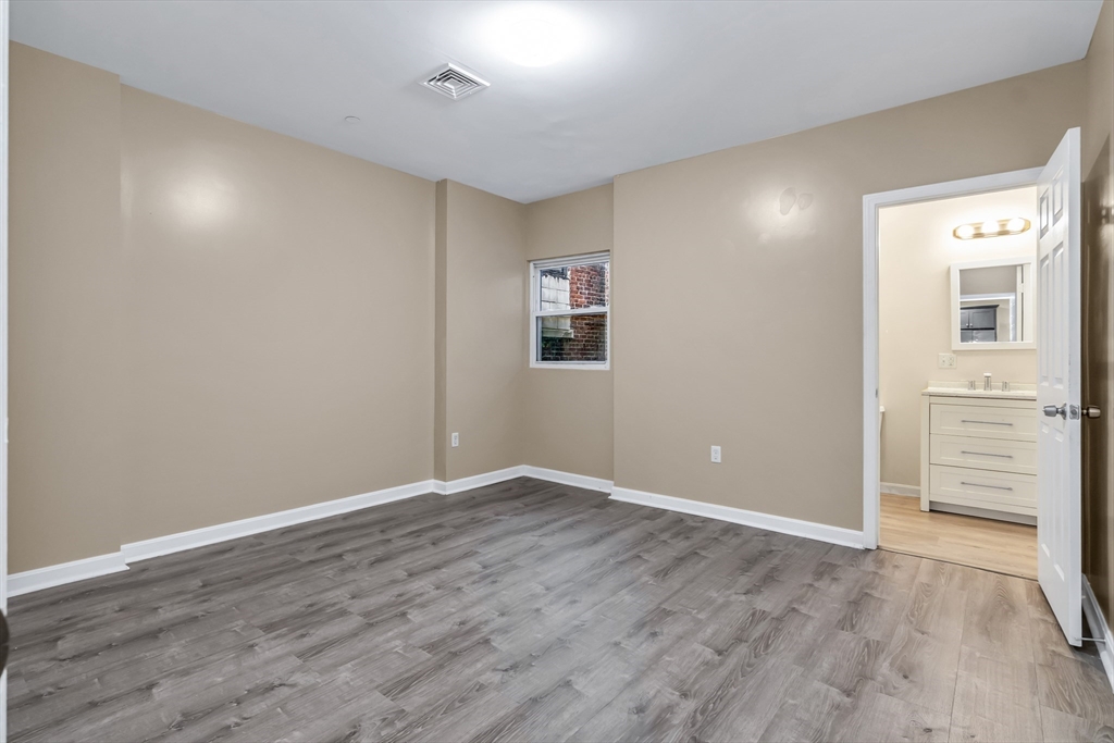 202 Broadway, Unit 23 Lawrence, MA 01840 - Photo 3 of 15 wooden floor in an empty room with a window