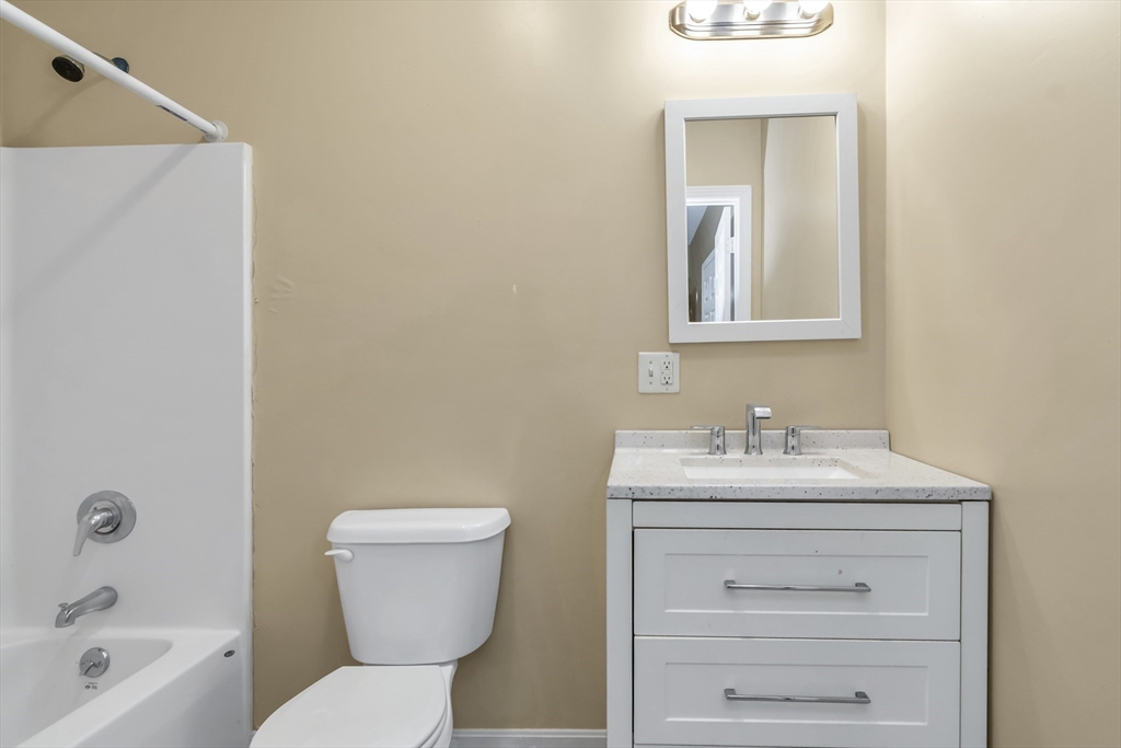 202 Broadway, Unit 23 Lawrence, MA 01840 - Photo 4 of 15 a bathroom with a sink a toilet and mirror
