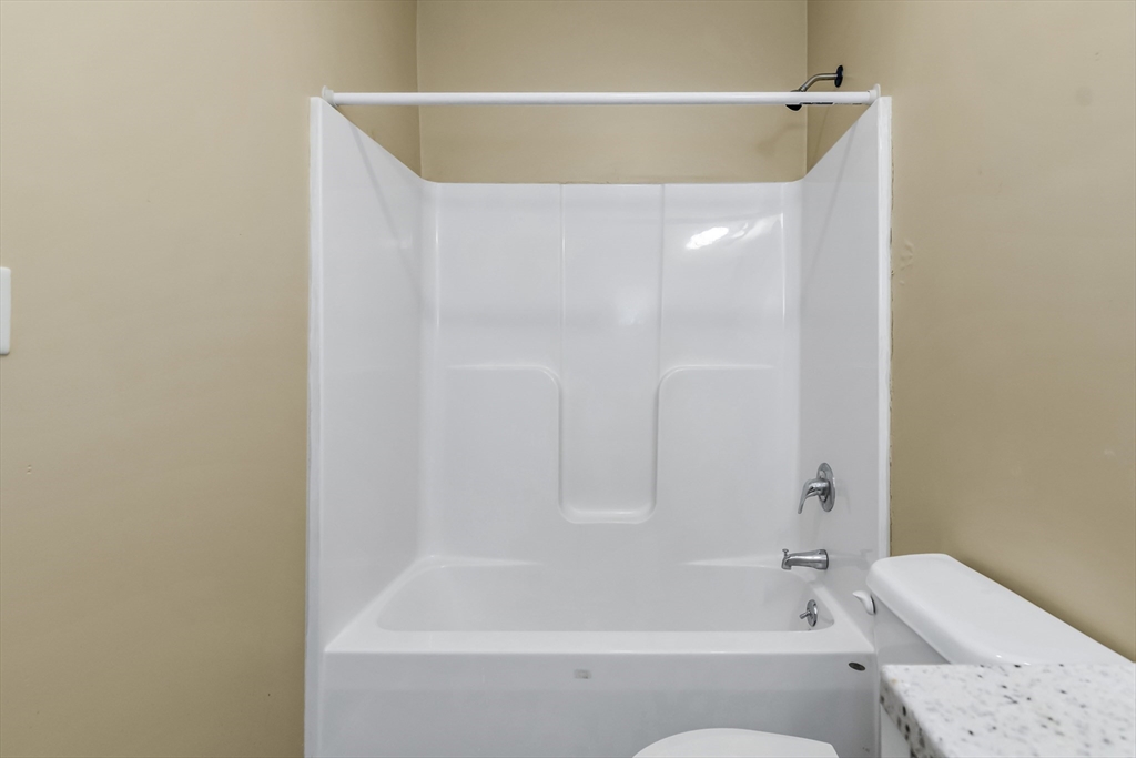 202 Broadway, Unit 23 Lawrence, MA 01840 - Photo 5 of 15 a bathroom with a bathtub and a toilet