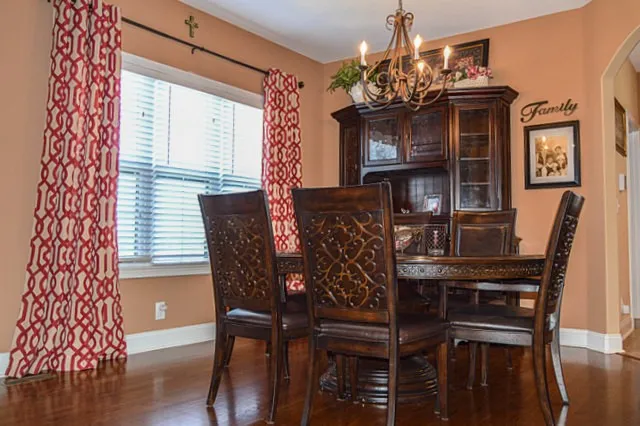a bedroom with a bed a chandelier and a window