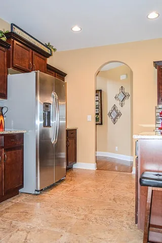 a shelf with books and a kitchen view
