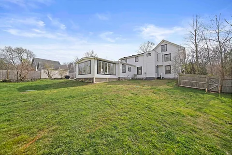 a view of a house with a big yard and large trees