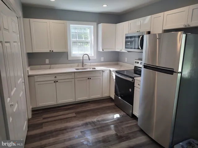 a kitchen with a sink a refrigerator and cabinets
