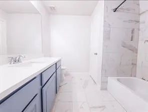 a bathroom with a sink vanity tub and shower