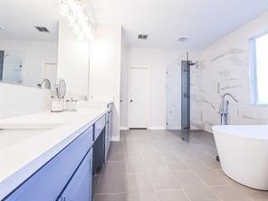 1424 Winston Drive McKinney, TX 75072 - Photo 24 of 28 a spacious bathroom with a double vanity sink a mirror and a bathtub