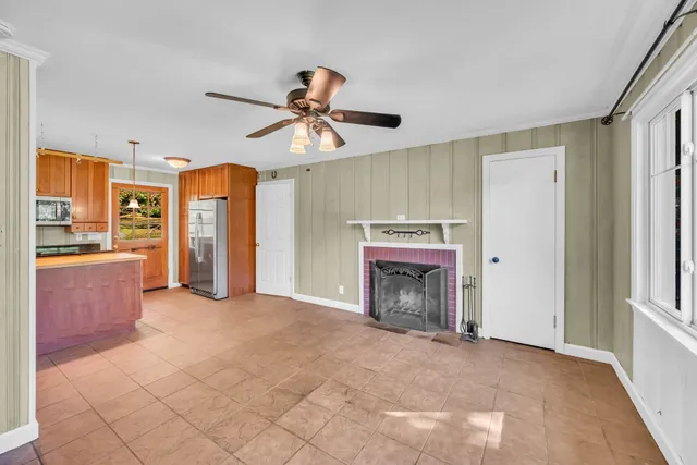 a view of an empty room with a fireplace and a window