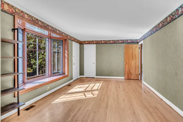 a view of a room with wooden floor and a window