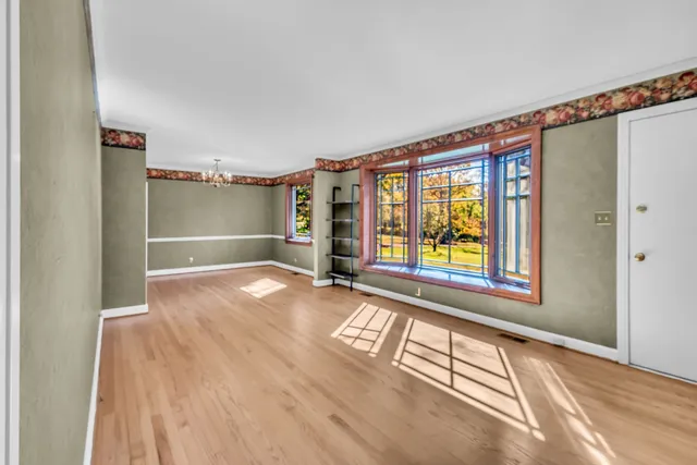 a view of empty room with window and wooden floor