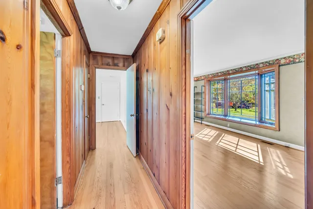 a view of a hallway with wooden floor and staircase