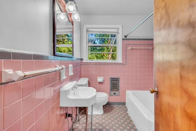 a bathroom with a sink a bathtub and next to a window