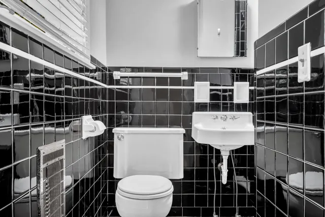 a bathroom with a toilet a sink and mirror
