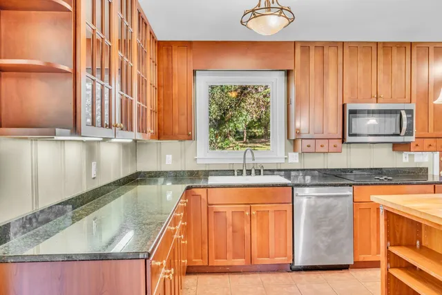 a kitchen with granite countertop a sink a stove and a microwave