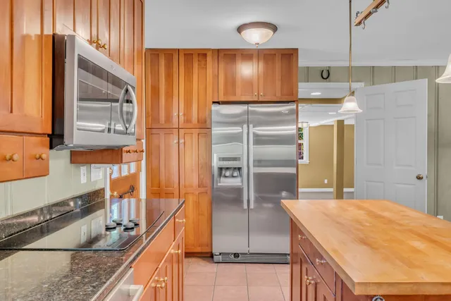 a kitchen with stainless steel appliances granite countertop a refrigerator and a stove