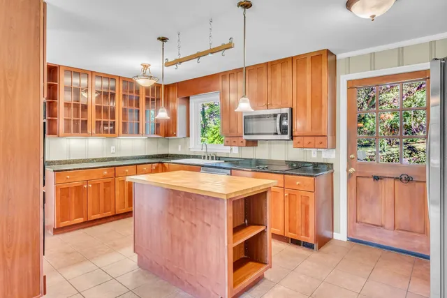 a kitchen with stainless steel appliances granite countertop wooden cabinets a sink and a large window