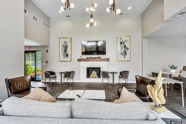 2000 Chestnut Avenue, Unit 407 Glenview, IL 60025 - Photo 17 of 25 a living room with furniture a flat screen tv and a fireplace